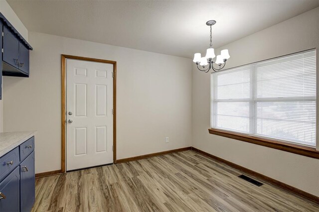 520 SE 47th St, Oklahoma City, OK 73129 - unfurnished dining area with light wood-type flooring, a chandelier, and baseboards