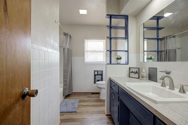 520 SE 47th St, Oklahoma City, OK 73129 - bathroom with tile walls, vanity, wood finished floors, toilet, and shower / tub combo with curtain