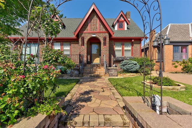 2113 N Gatewood Ave, Oklahoma City, OK 73106 - tudor home with brick siding, roof with shingles, and a chimney