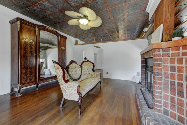 2113 N Gatewood Ave, Oklahoma City, OK 73106 - living area featuring ornamental molding, a fireplace, a ceiling fan, arched walkways, and wood finished floors