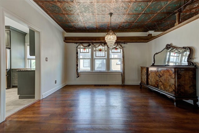 2113 N Gatewood Ave, Oklahoma City, OK 73106 - unfurnished dining area with a chandelier, crown molding, wood finished floors, an ornate ceiling, and baseboards