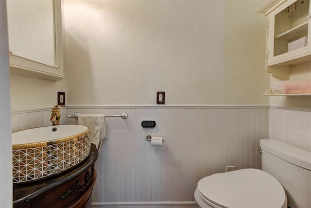 2113 N Gatewood Ave, Oklahoma City, OK 73106 - half bathroom featuring toilet and a wainscoted wall