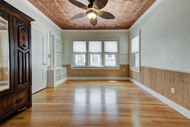 2113 N Gatewood Ave, Oklahoma City, OK 73106 - unfurnished room with an ornate ceiling, a ceiling fan, light wood-type flooring, a wainscoted wall, and wood walls