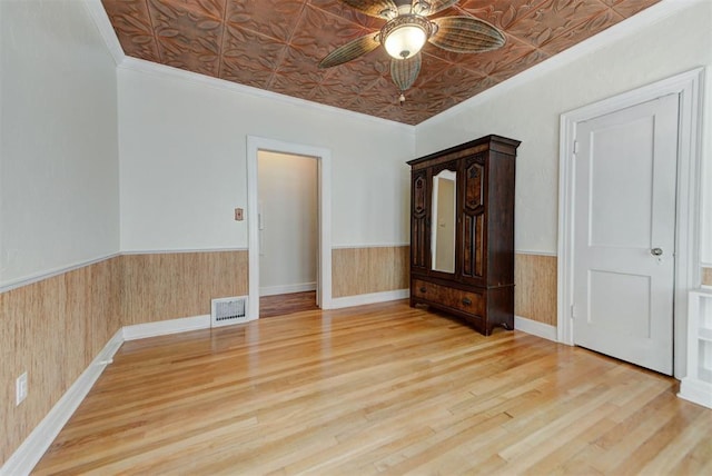 2113 N Gatewood Ave, Oklahoma City, OK 73106 - unfurnished bedroom with an ornate ceiling, a wainscoted wall, crown molding, wood finished floors, and ceiling fan