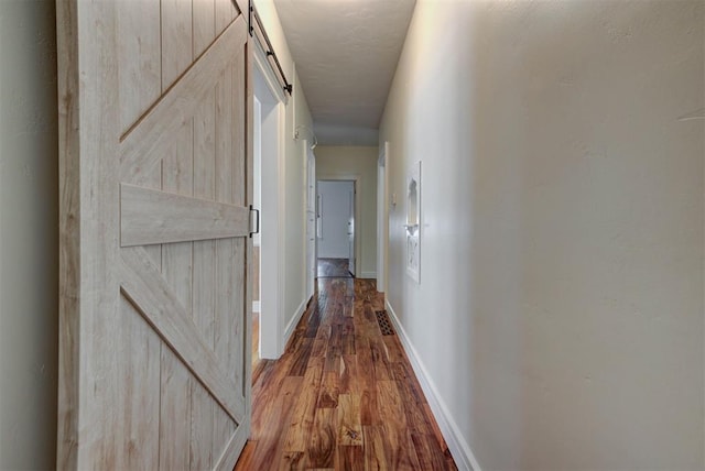2113 N Gatewood Ave, Oklahoma City, OK 73106 - corridor featuring wood finished floors, a barn door, and baseboards