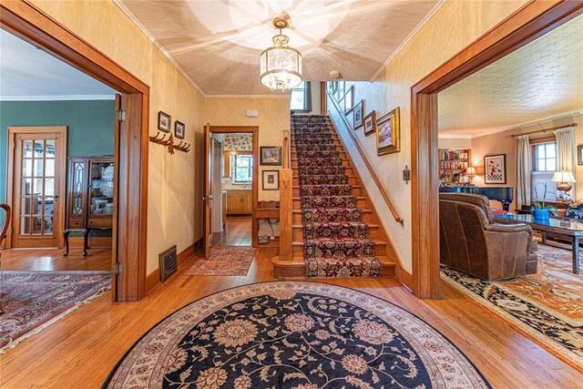 1527 NW 35th St, Oklahoma City, OK 73118 - foyer entrance with hardwood / wood-style floors, stairs, a chandelier, crown molding, and baseboards