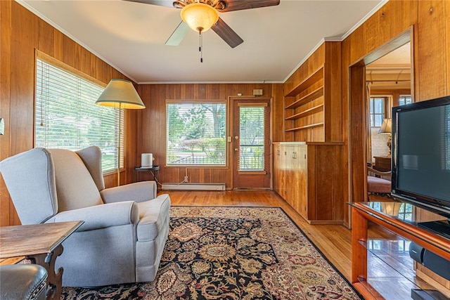 1527 NW 35th St, Oklahoma City, OK 73118 - living area featuring a baseboard radiator, crown molding, wood walls, light wood finished floors, and ceiling fan