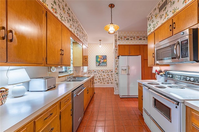 1527 NW 35th St, Oklahoma City, OK 73118 - kitchen with wallpapered walls, stainless steel appliances, a sink, light countertops, and brown cabinetry