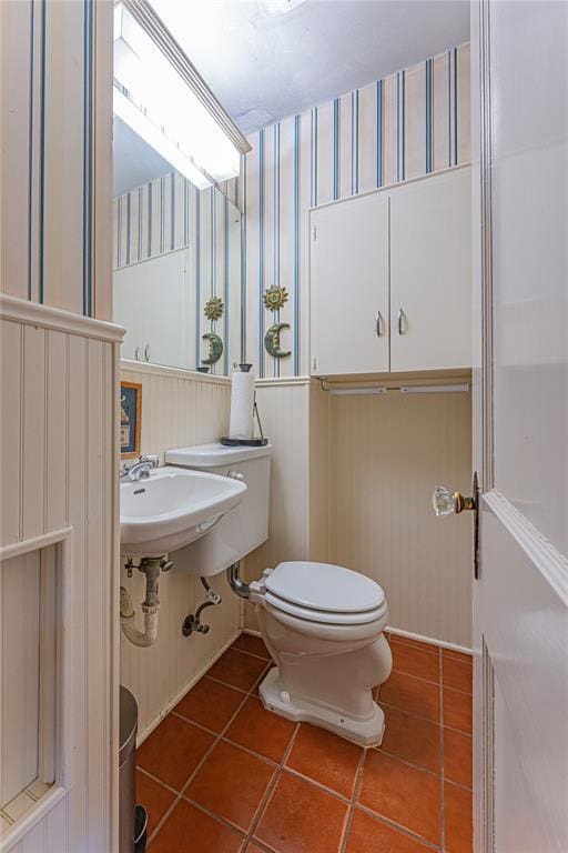 1527 NW 35th St, Oklahoma City, OK 73118 - half bath featuring wallpapered walls, tile patterned flooring, wainscoting, and toilet