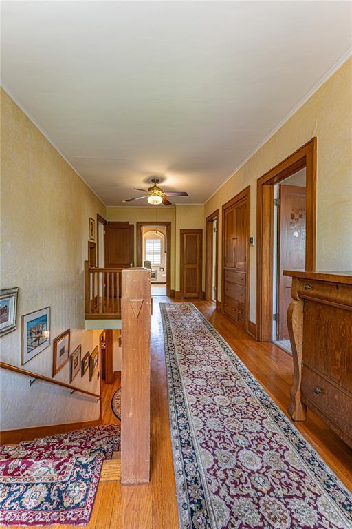 1527 NW 35th St, Oklahoma City, OK 73118 - hall with wood finished floors, crown molding, and an upstairs landing