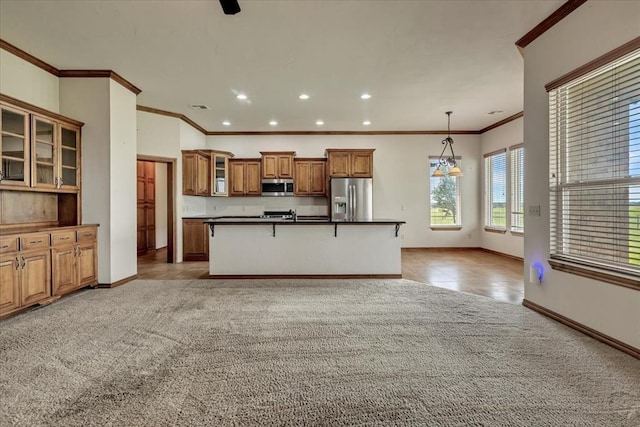 104 Southpointe Ave, Tuttle, OK 73089 - kitchen featuring stainless steel appliances, brown cabinetry, baseboards, crown molding, and dark countertops