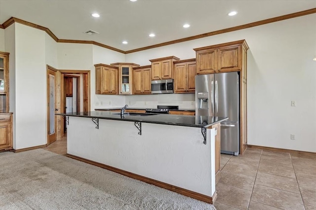104 Southpointe Ave, Tuttle, OK 73089 - kitchen with stainless steel appliances, a kitchen breakfast bar, brown cabinets, dark countertops, and recessed lighting
