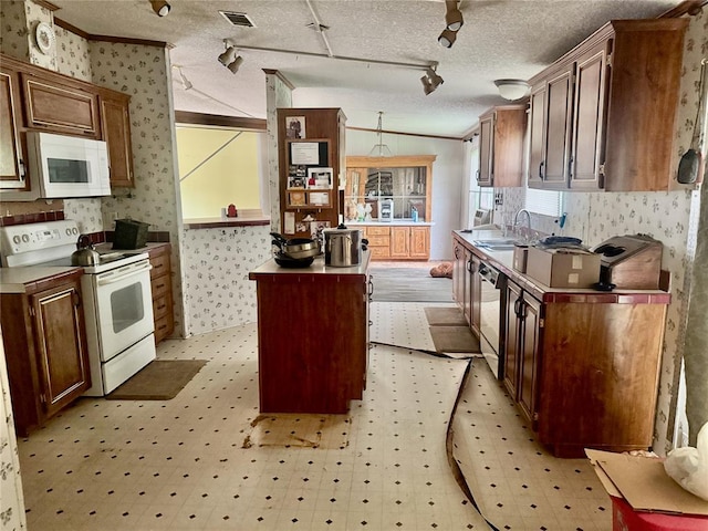 19350 8 A St, Norman, OK 73026 - kitchen featuring white appliances, wallpapered walls, a sink, light floors, and track lighting