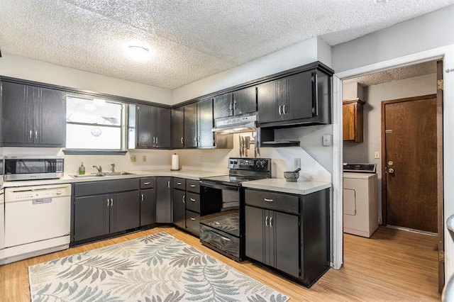 829 Douglas Dr, Norman, OK 73069 - kitchen featuring washer / clothes dryer, black range with electric stovetop, stainless steel microwave, white dishwasher, and under cabinet range hood