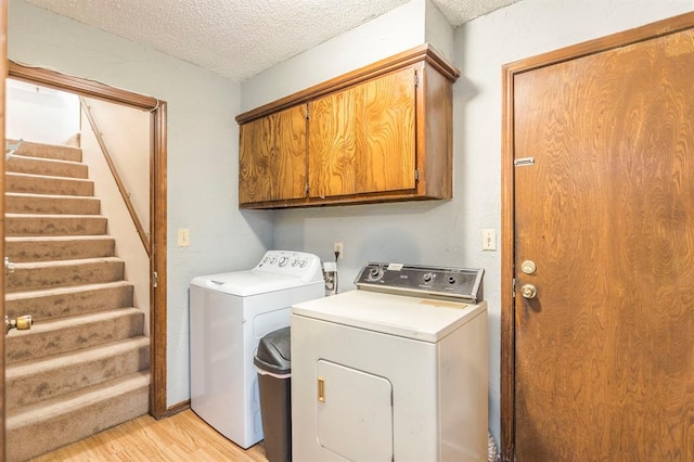 829 Douglas Dr, Norman, OK 73069 - laundry room featuring cabinet space, independent washer and dryer, a textured ceiling, and light wood finished floors