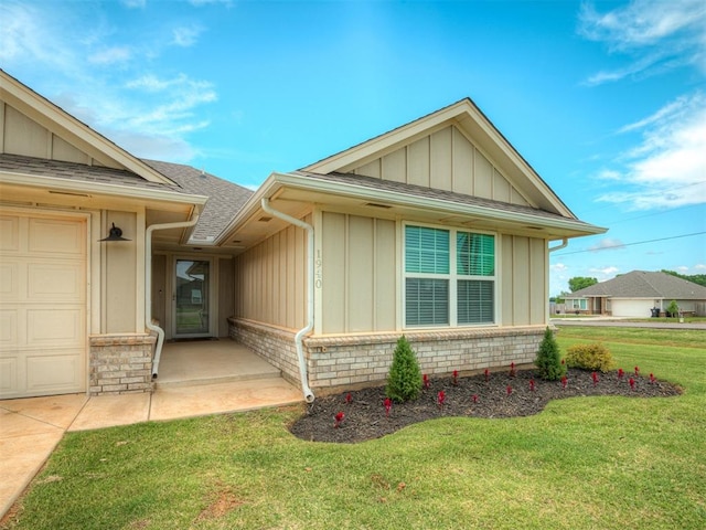 1940 Eli Ave, Tuttle, OK 73089 - view of front facade with board and batten siding, a front yard, roof with shingles, and brick siding