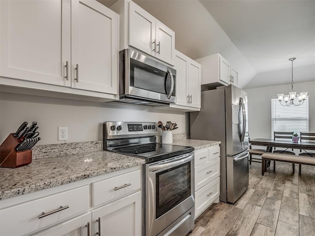 1940 Eli Ave, Tuttle, OK 73089 - kitchen featuring appliances with stainless steel finishes, white cabinets, light wood-style floors, a chandelier, and lofted ceiling