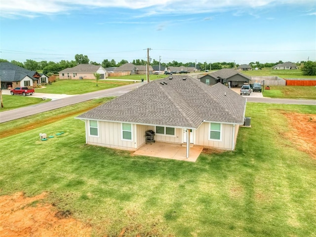 1940 Eli Ave, Tuttle, OK 73089 - rear view of house with roof with shingles, a residential view, a patio, and a yard