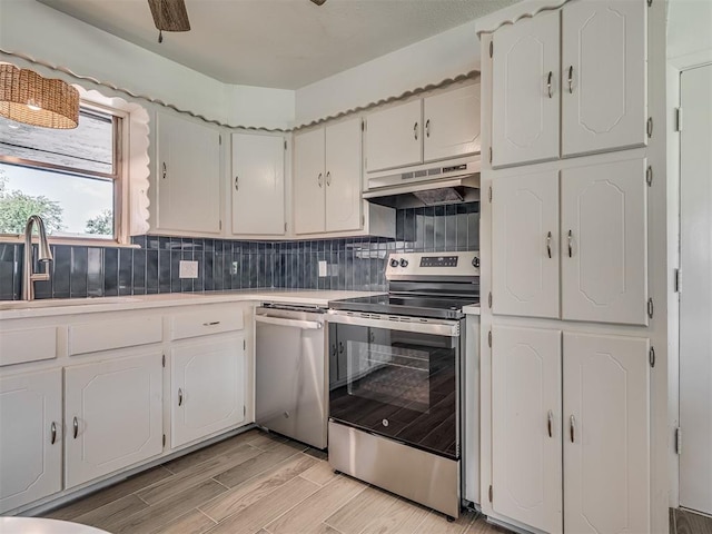 2117 SW 76th St, Oklahoma City, OK 73159 - kitchen with appliances with stainless steel finishes, under cabinet range hood, a sink, and white cabinets