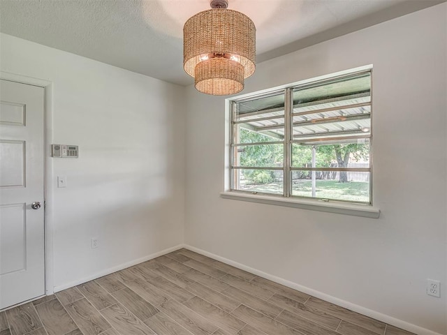 2117 SW 76th St, Oklahoma City, OK 73159 - spare room with a chandelier, wood finish floors, and baseboards