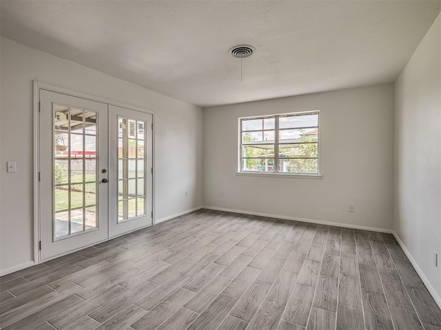 2117 SW 76th St, Oklahoma City, OK 73159 - spare room with french doors, wood finished floors, and baseboards