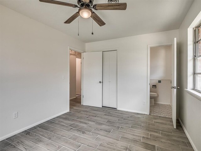 2117 SW 76th St, Oklahoma City, OK 73159 - unfurnished bedroom with wood tiled floors, ensuite bathroom, a closet, and ceiling fan