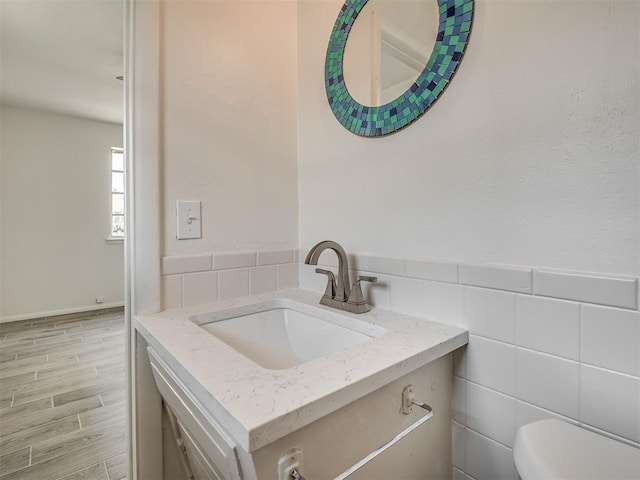 2117 SW 76th St, Oklahoma City, OK 73159 - bathroom with vanity, toilet, wood finished floors, and tile walls