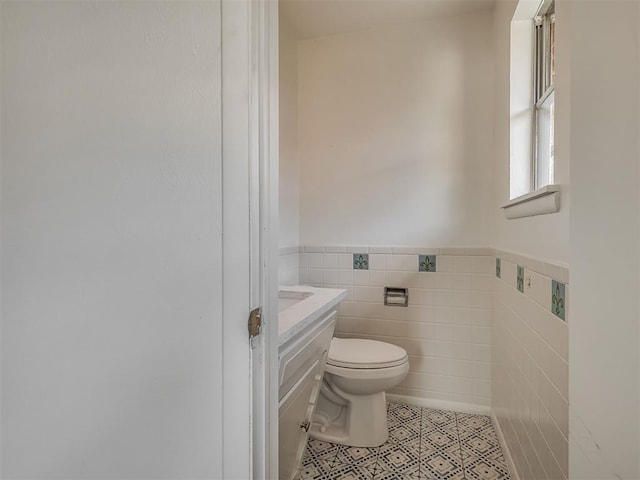 2117 SW 76th St, Oklahoma City, OK 73159 - half bathroom with toilet, tile walls, wainscoting, vanity, and tile patterned flooring