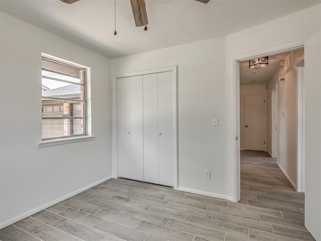 2117 SW 76th St, Oklahoma City, OK 73159 - unfurnished bedroom with wood tiled floors, baseboards, a closet, and a ceiling fan