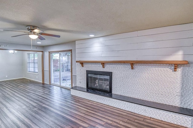 1439 Greenbriar Dr, Norman, OK 73072 - unfurnished living room featuring wood finished floors, a textured ceiling, baseboards, a ceiling fan, and a fireplace