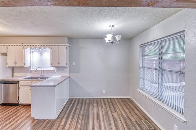 1439 Greenbriar Dr, Norman, OK 73072 - kitchen featuring a sink, dishwasher, wood finished floors, white cabinets, and a textured ceiling