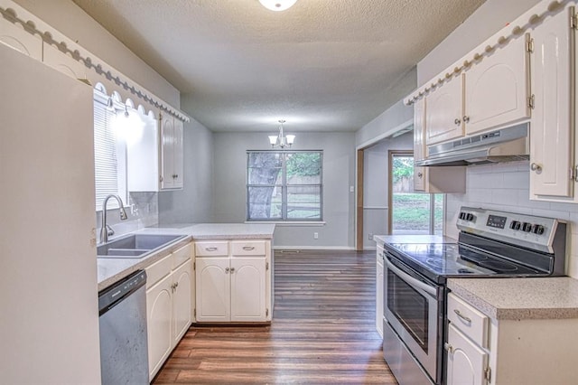 1439 Greenbriar Dr, Norman, OK 73072 - kitchen with stainless steel appliances, under cabinet range hood, a sink, a peninsula, and a textured ceiling