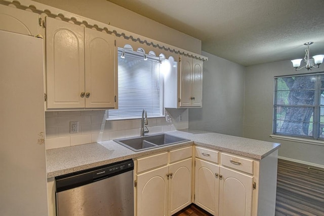 1439 Greenbriar Dr, Norman, OK 73072 - kitchen with stainless steel dishwasher, a sink, a peninsula, a chandelier, and light countertops
