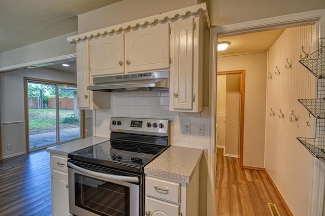 1439 Greenbriar Dr, Norman, OK 73072 - kitchen with electric stove, under cabinet range hood, wood finished floors, and light countertops