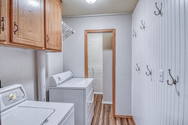 1439 Greenbriar Dr, Norman, OK 73072 - washroom featuring washing machine and clothes dryer, dark wood-type flooring, cabinet space, and a textured ceiling
