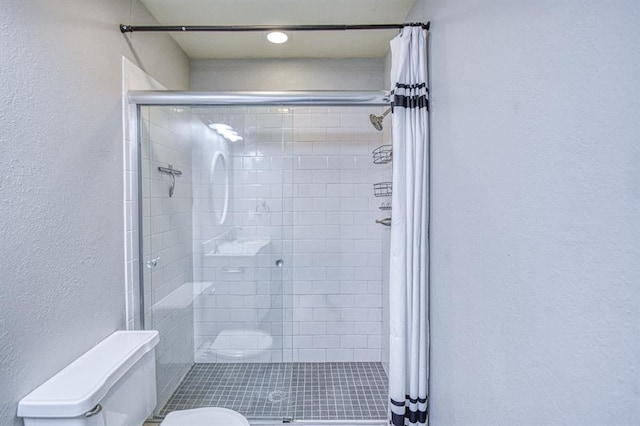 1439 Greenbriar Dr, Norman, OK 73072 - bathroom with toilet, a textured wall, and a shower stall