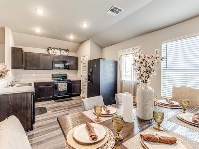 1316 Chuck Wagon Dr, El Reno, OK 73036 - kitchen with black appliances, a sink, light wood-style floors, dark brown cabinetry, and light countertops