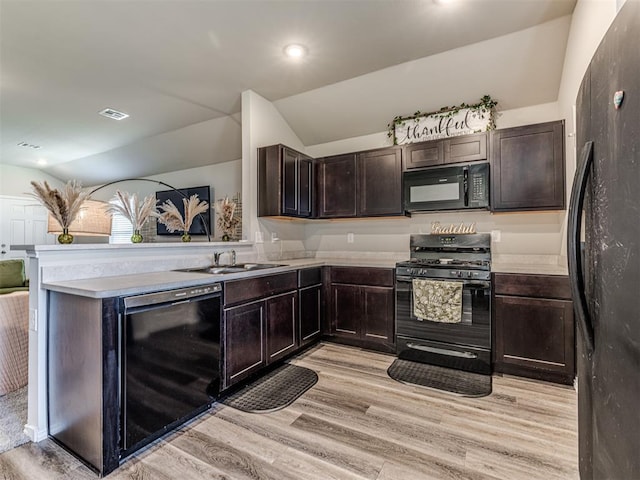 1316 Chuck Wagon Dr, El Reno, OK 73036 - kitchen with black appliances, vaulted ceiling, light wood-type flooring, light countertops, and a sink