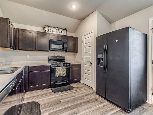 1316 Chuck Wagon Dr, El Reno, OK 73036 - kitchen featuring black appliances, vaulted ceiling, light wood-style flooring, and dark brown cabinets
