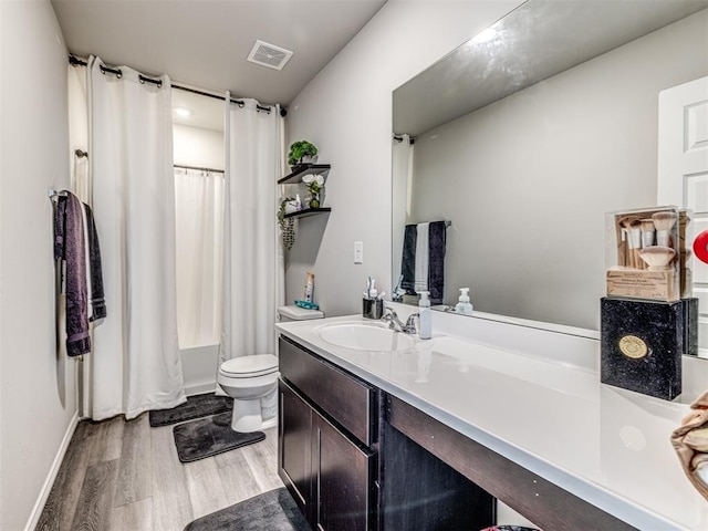 1316 Chuck Wagon Dr, El Reno, OK 73036 - bathroom featuring vanity, toilet, wood finished floors, shower / bath combo with shower curtain, and baseboards