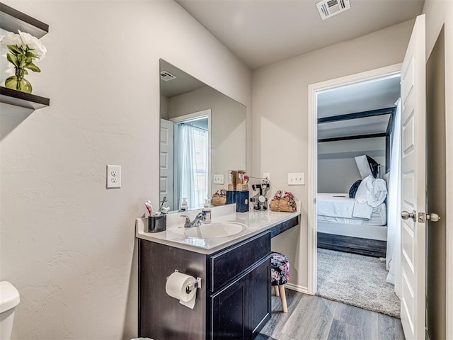 1316 Chuck Wagon Dr, El Reno, OK 73036 - bathroom with wood finished floors, vanity, toilet, baseboards, and ensuite bath