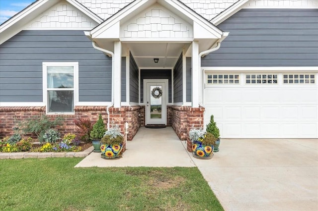 13091 Mannington Rd, Edmond, OK 73025 - doorway to property featuring a garage, concrete driveway, and brick siding