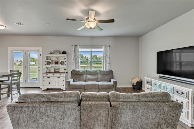13091 Mannington Rd, Edmond, OK 73025 - living area with plenty of natural light, wood finished floors, ceiling fan, and baseboards
