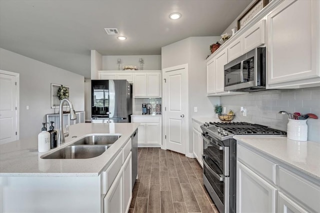 13091 Mannington Rd, Edmond, OK 73025 - kitchen featuring stainless steel appliances, a sink, a center island with sink, white cabinets, and recessed lighting