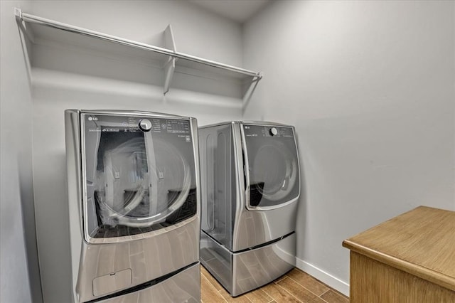 13091 Mannington Rd, Edmond, OK 73025 - washroom featuring baseboards, wood tiled floors, and washing machine and dryer