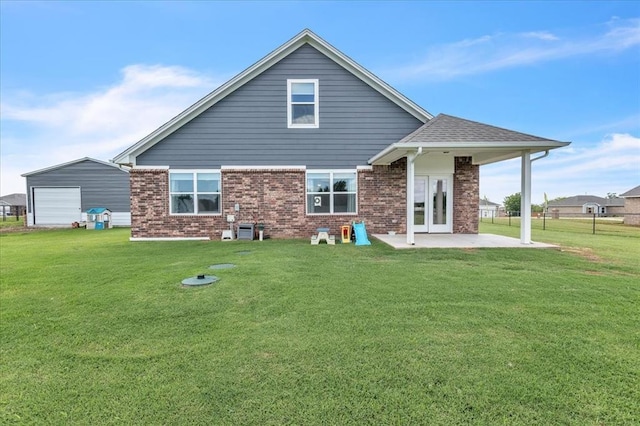 13091 Mannington Rd, Edmond, OK 73025 - back of property with a patio, a yard, a detached garage, and brick siding