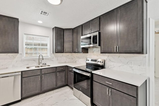 2617 SW 69th St, Oklahoma City, OK 73159 - kitchen featuring stainless steel appliances, dark brown cabinets, light marble finish flooring, light countertops, and backsplash
