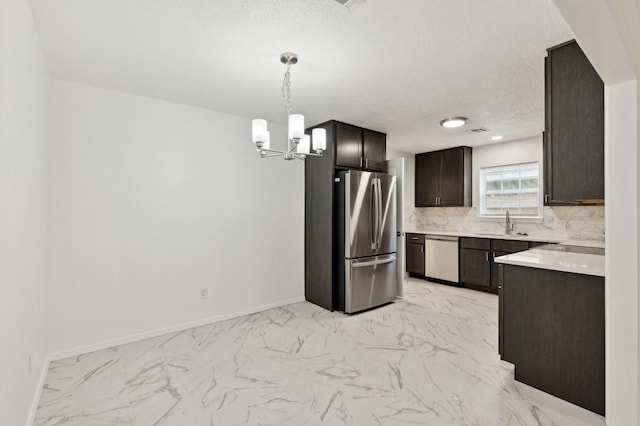 2617 SW 69th St, Oklahoma City, OK 73159 - kitchen featuring appliances with stainless steel finishes, a chandelier, backsplash, light marble finish flooring, and a textured ceiling