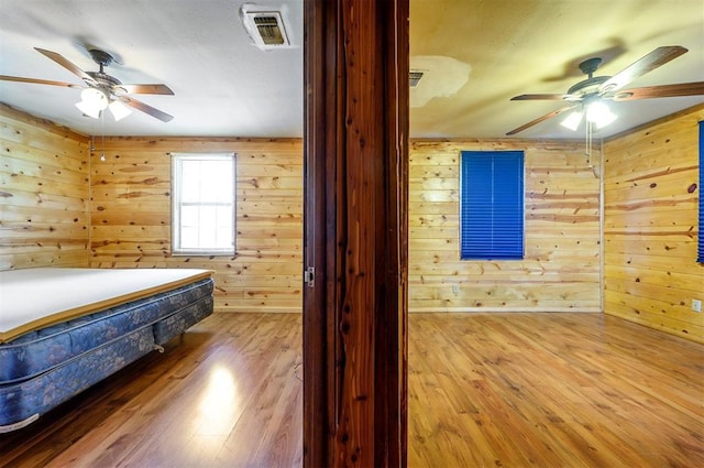431 Canoe Rd, Broken Bow, OK 74728 - bedroom with wood finished floors, wooden walls, and a ceiling fan
