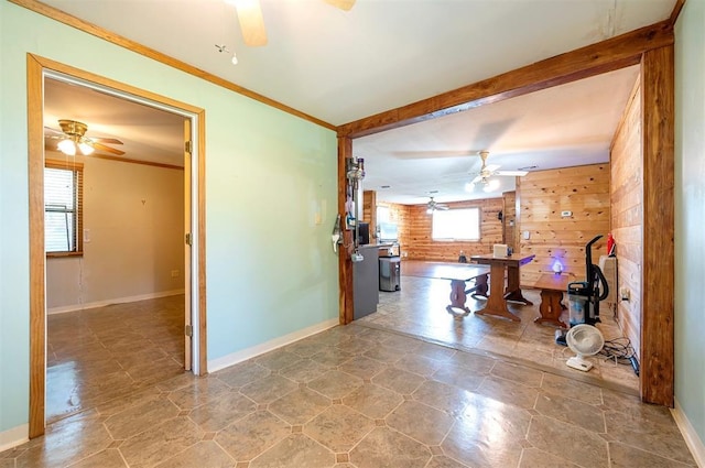 431 Canoe Rd, Broken Bow, OK 74728 - unfurnished living room with a ceiling fan, wood walls, baseboards, ornamental molding, and beamed ceiling